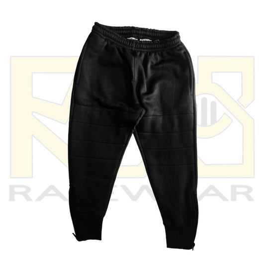 A pair of black OrthoEase Adaptive TrackPants for kids, featuring an elastic waistband with drawstring, double knee design, and ankle zips.