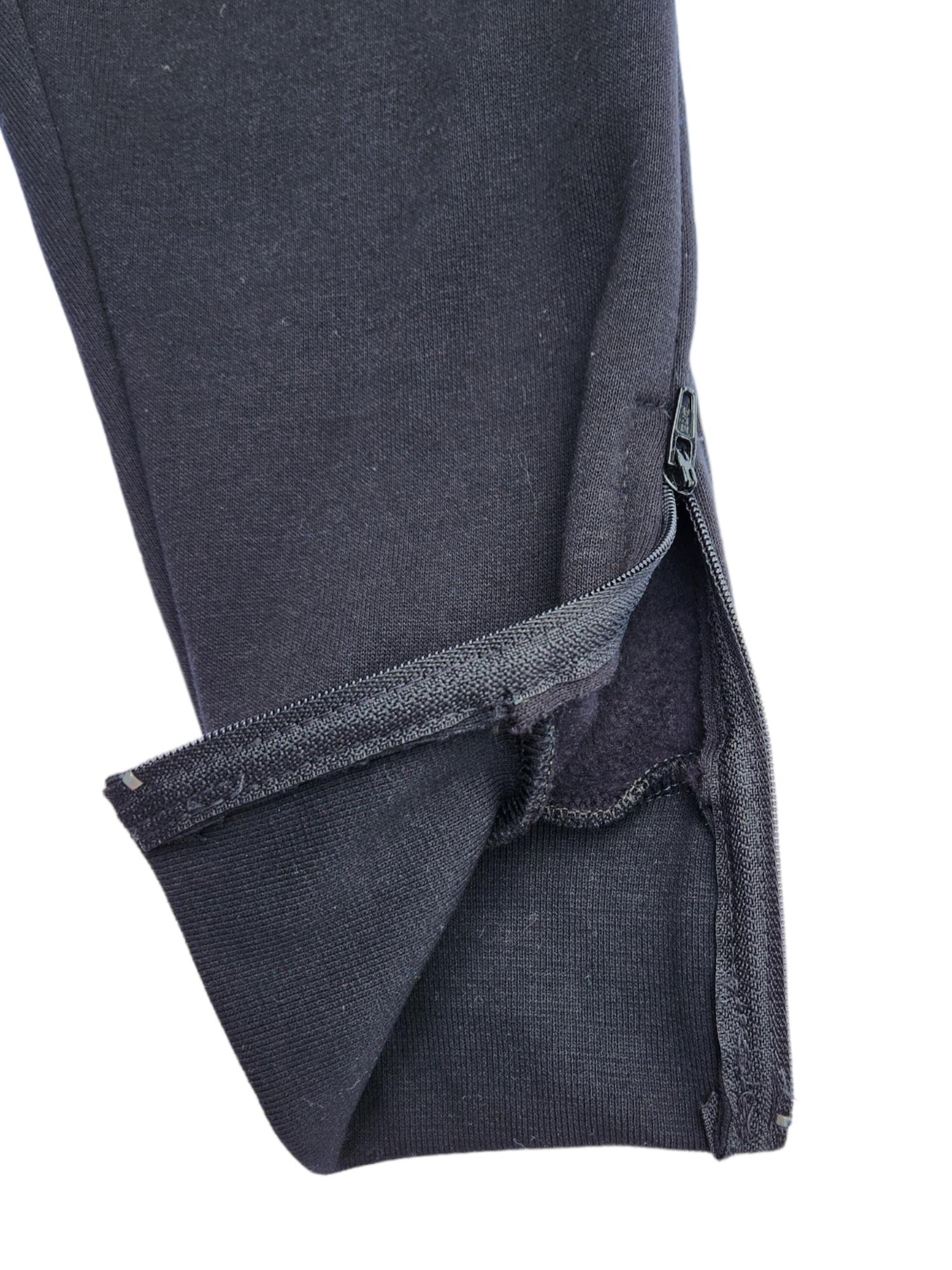 Ankle portion of black track pants featuring zip access