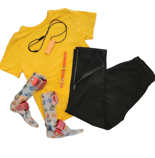 Adaptive Lloyd cotton polyester Black Trouser with yellow cotton shirt, orange chewy toy, colourful rainbow ankle foot orthotics, orange Texta and yellow ezy hold adaptive device 